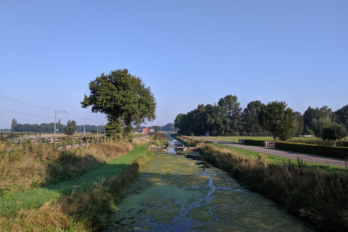 afbeelding van een landschap met een sloot en bomen in Heino.