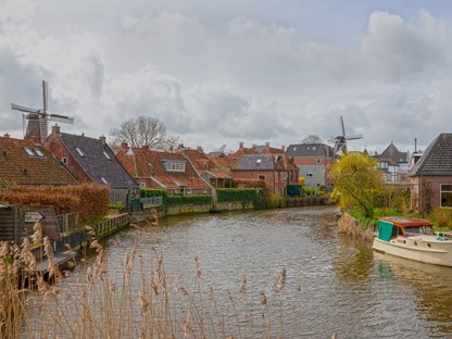 drop gelegen aan het water met windmolens op de achtergrond