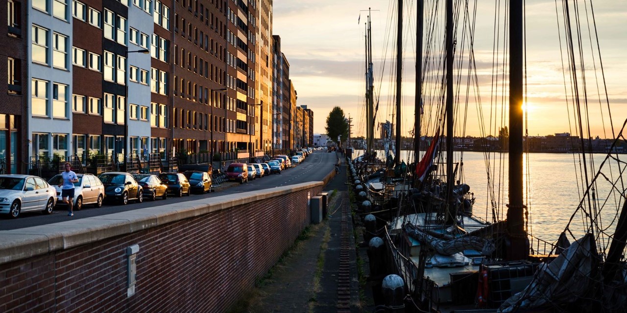 afbeelding van een ondergaande zon aan de kade met boten op Java-eiland Amsterdam.