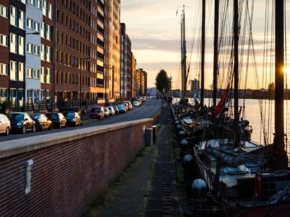 afbeelding van een ondergaande zon aan de kade met boten op Java-eiland Amsterdam.