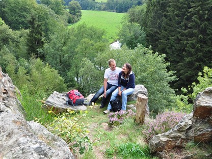 Wandelaars genieten zittend op een steen van het landschap, © Natalie Glatter, www.wandermagazin.de