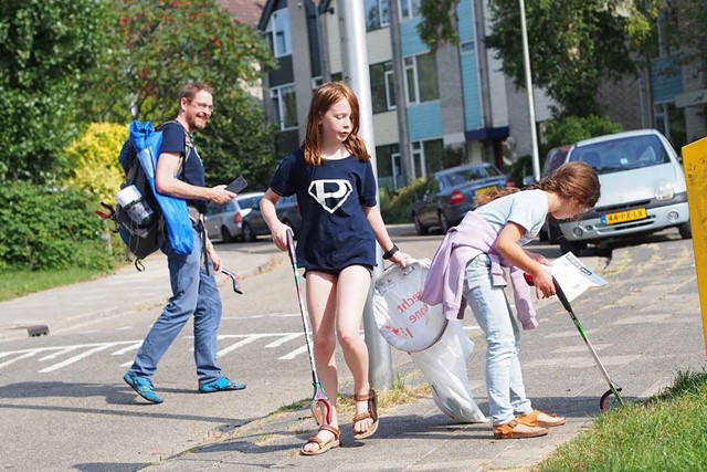 Plandelman en kinderen rapen afval in Lunetten.