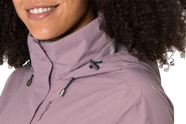 afbeelding van een vrouw met een regenjas van VAUDE.