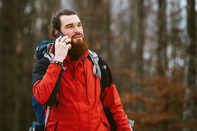 Hipster met telefoon aan het wandelen