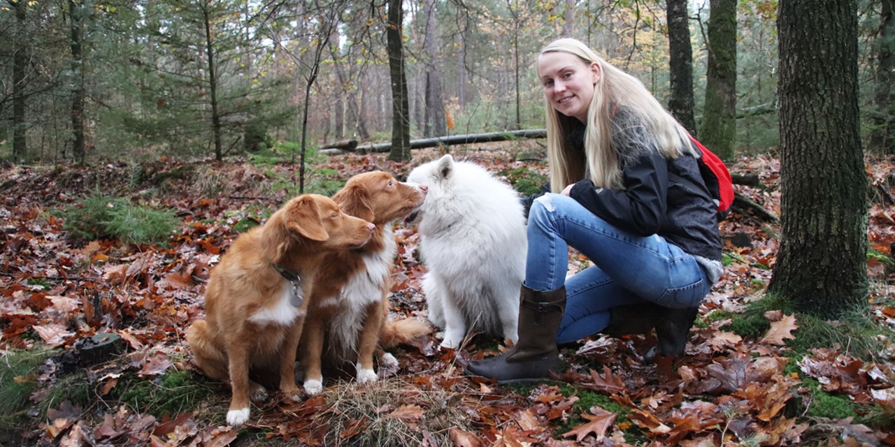 afbeelding van Trinke met haar Sutherland outdoorlaarzen aan en haar honden om haar heen.