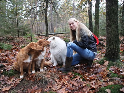 afbeelding van Trinke met haar Sutherland outdoorlaarzen aan en haar honden om haar heen.