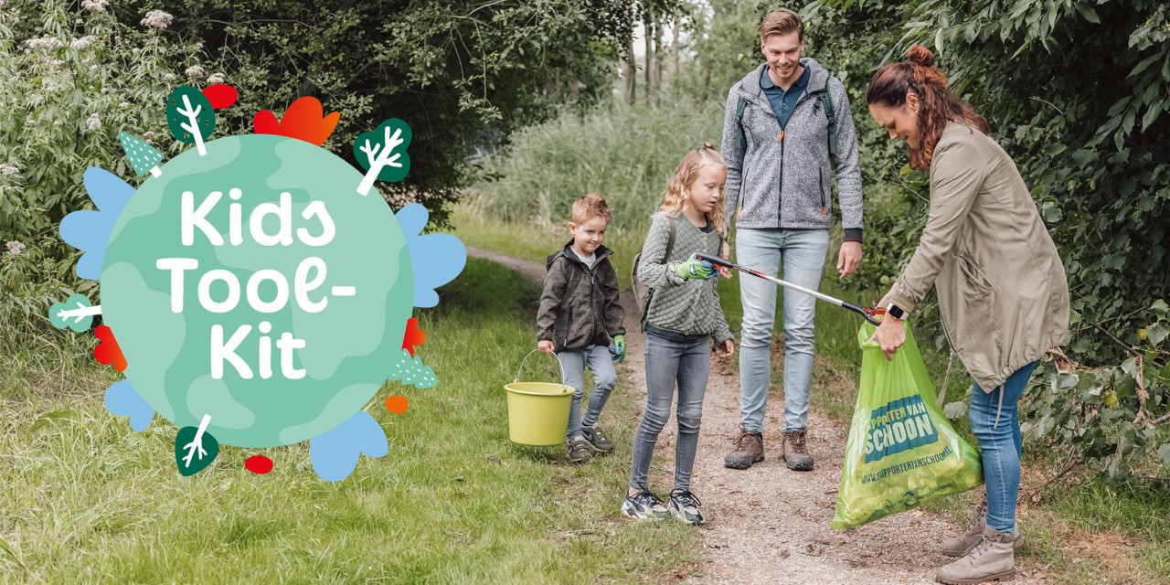 Gezin staat in het bos en dochter gooit afval in vuilniszak die moeder openhoudt.