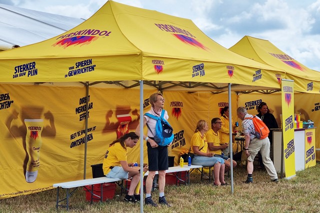vrouw laat haar benen insprayen met Perskindol op een stand tijdens de 4Daagse.