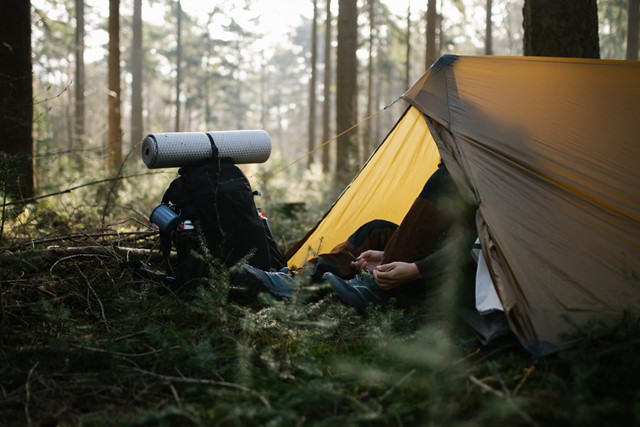 afbeelding van een tent en een rugzak in het bos