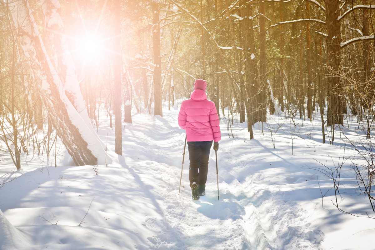 afbeelding van een wandelaar in de winter, met Nordic Walking stokken.
