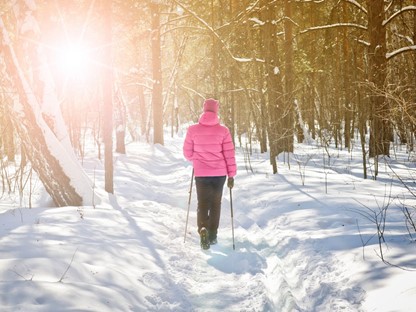 afbeelding van een wandelaar in de winter, met Nordic Walking stokken.