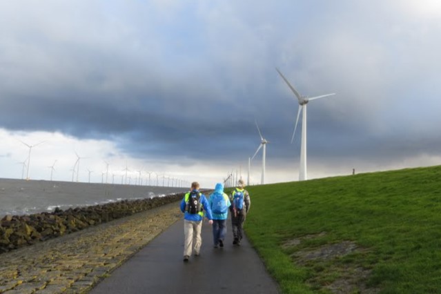 afbeelding van wandelaars in Emmeloord, met donkere wolken.