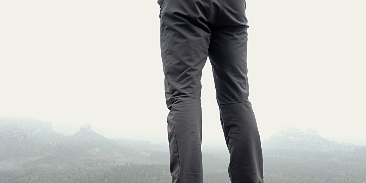 Man op berg met grijze wandelbroek aan