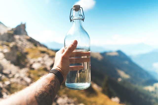 Water in een glazen fles in de bergen