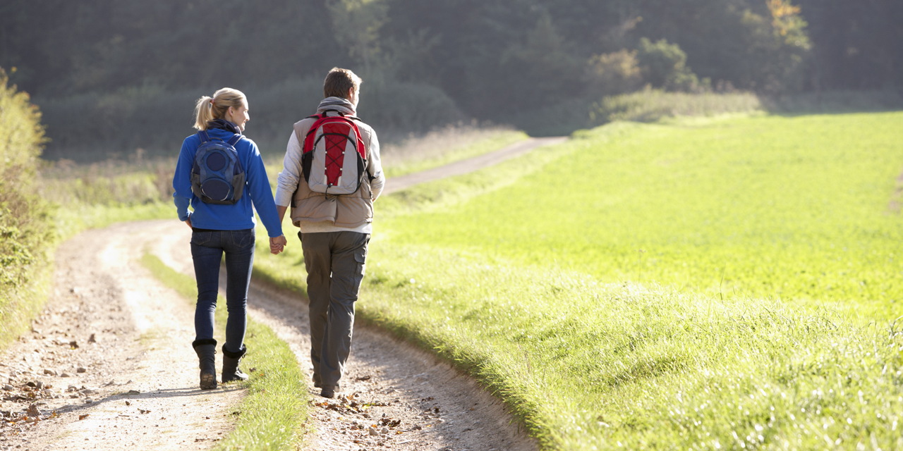 Man vrouw wandelend tussen weiland