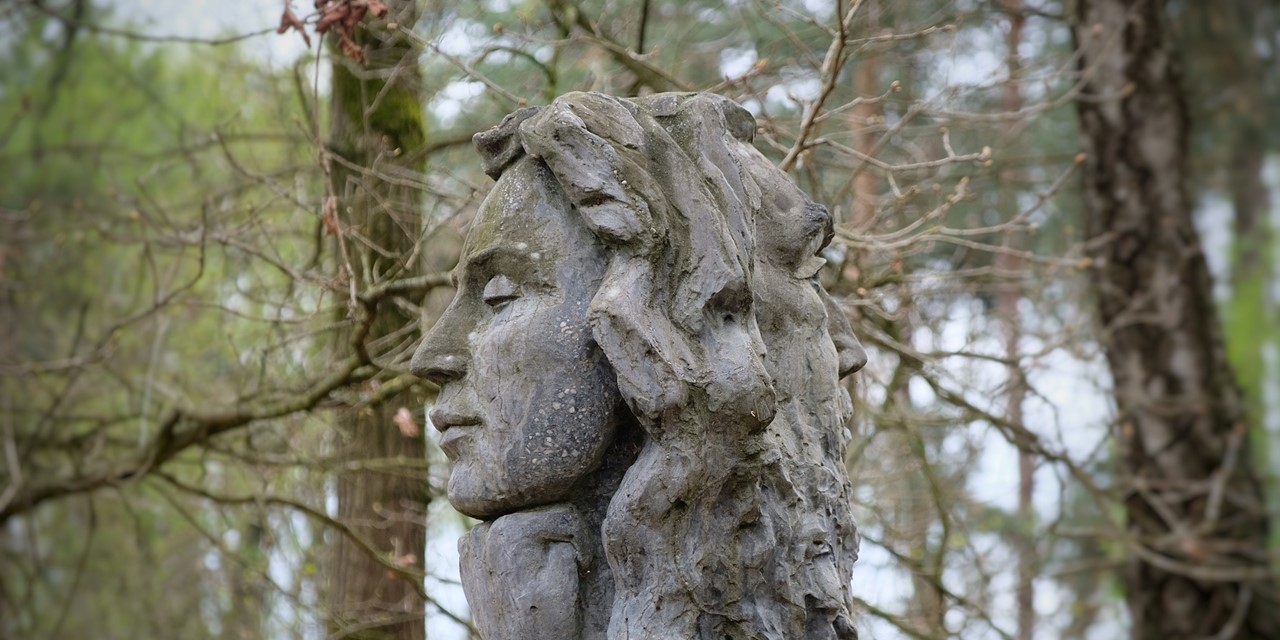 afbeelding van een stenen hoofd met een vrouwengezicht en mannengezicht.
