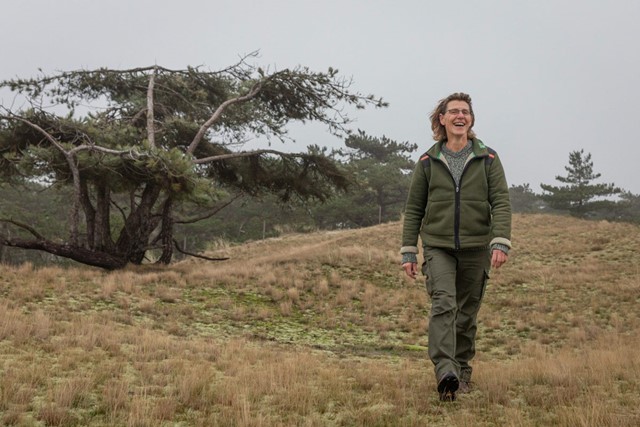 afbeelding van boswachter Mariëtte Smit op de rand van bos en duin. (Foto: © Evalien Weterings)