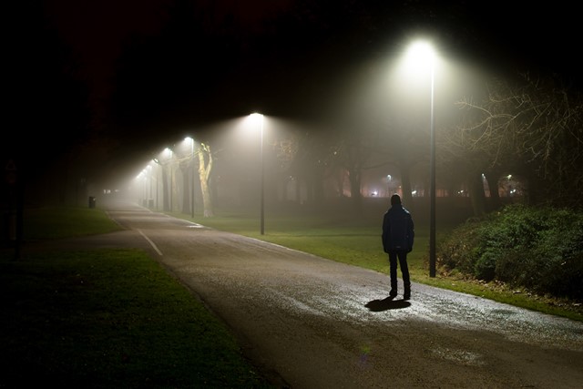 afbeelding van een wandelaar in het donker.