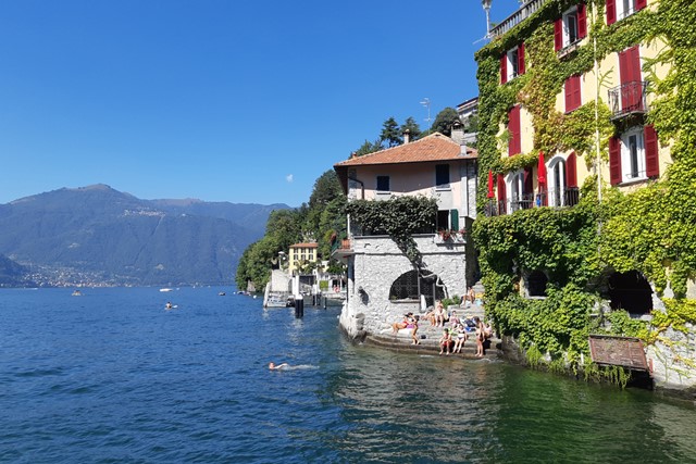 huizen en mensen aan het water van het Comomeer in Nesso.