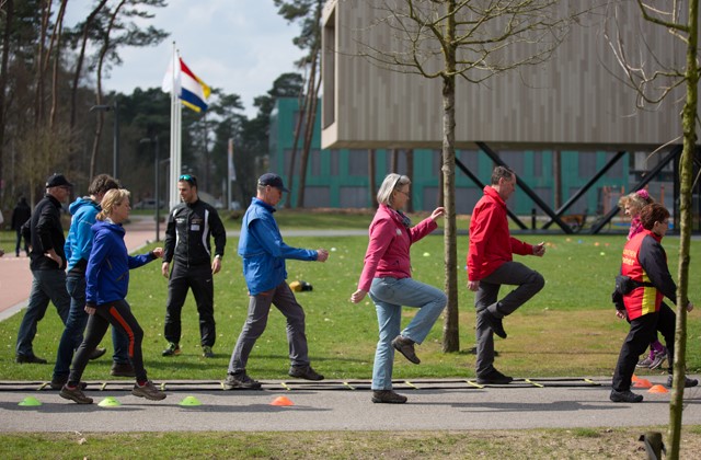 Mensen in sportkleding leggen een parcours af