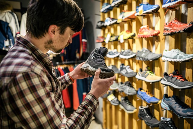 afbeelding van iemand die een wandelschoen uitzoekt in de winkel.