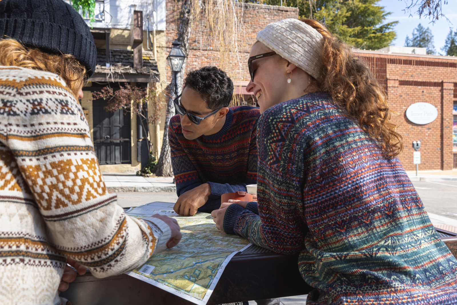 Drie wandelaars die de weg zoeken met een kaart.