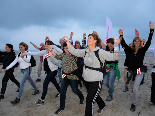 Juichende wandelaars op het strand.