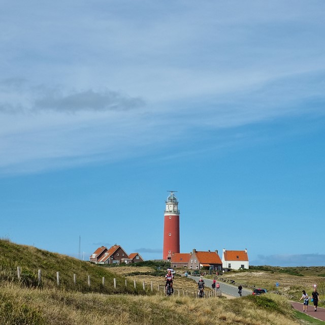 afbeelding van wandelaars en fietsers bij de vuurtoren van Texel.