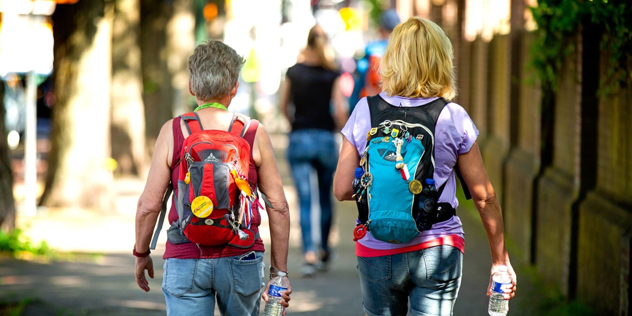 afbeelding van twee wandelaars in Den Haag in de zon.