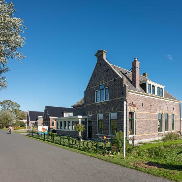 afbeelding van een oud schooltje tegen een blauwe lucht.