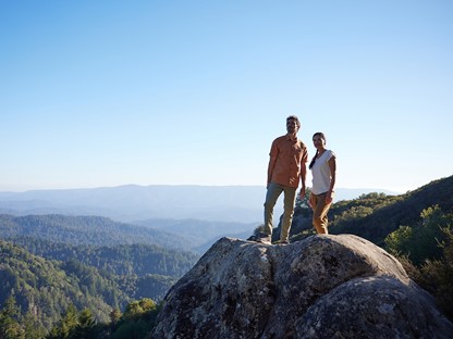 man en vrouw bovenop een berg in kleding van Royal Robbins.