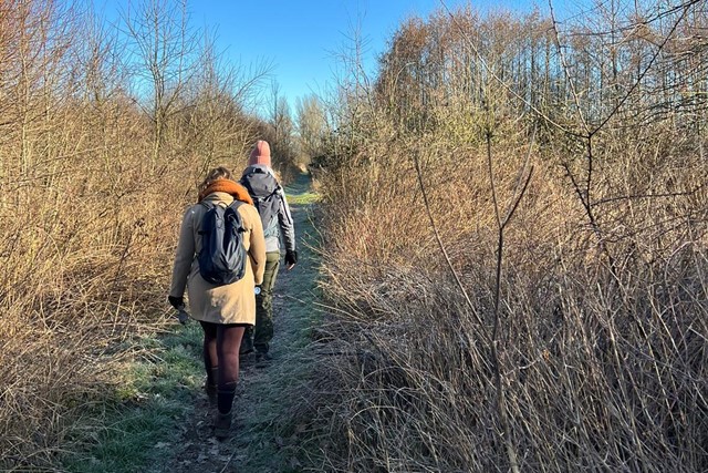 afbeelding van twee wandelaars in de natuur.