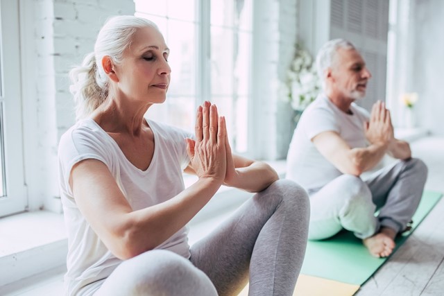 afbeelding van twee mensen die mediteren op een yogamat.