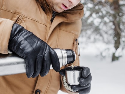 Man drink koffie uit thermosfles
