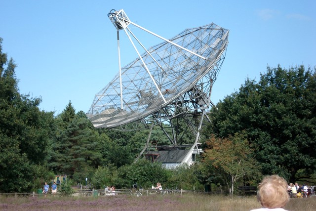 afbeelding van een grote radiotelescoop in de natuur.