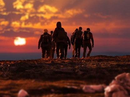 afbeelding van wandelaars in de avond