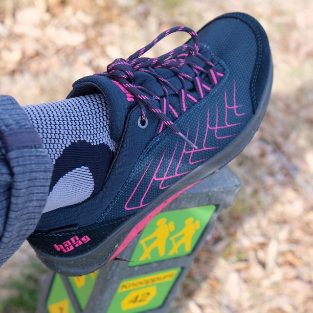 wandelschoen op een routepaaltje met wandelknooppunten.