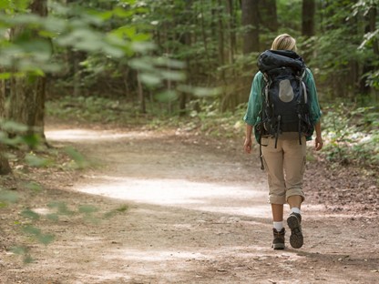 Vrouw wandelt in wandeloutfit door de natuur