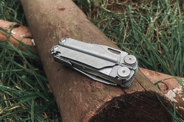 afbeelding van de handzame Leatherman, ingeklapt liggend op een boomstam.