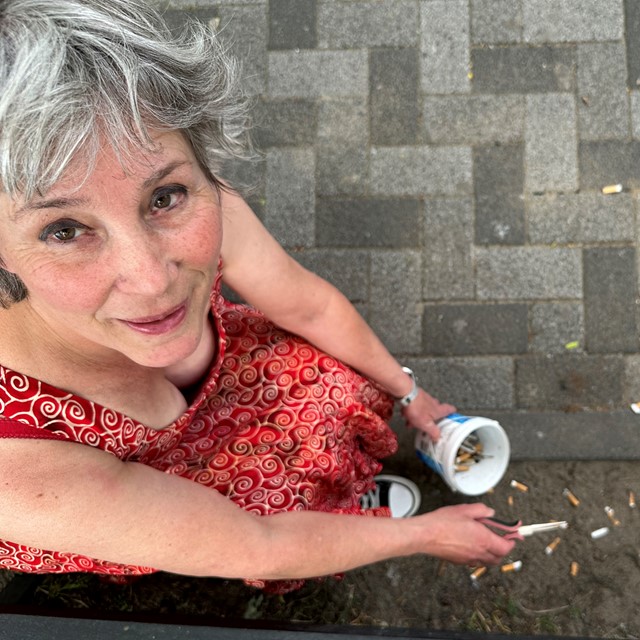 Peukenmeisje Bernadette met een bakje vol peuken die ze van straat raapt.