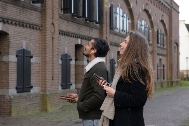 afbeelding van twee jonge wandelaars met een telefoon in hun hand.