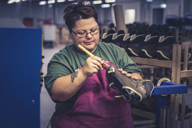 afbeelding van een vrouw die in een Hanwag-fabriek een schoen produceert.
