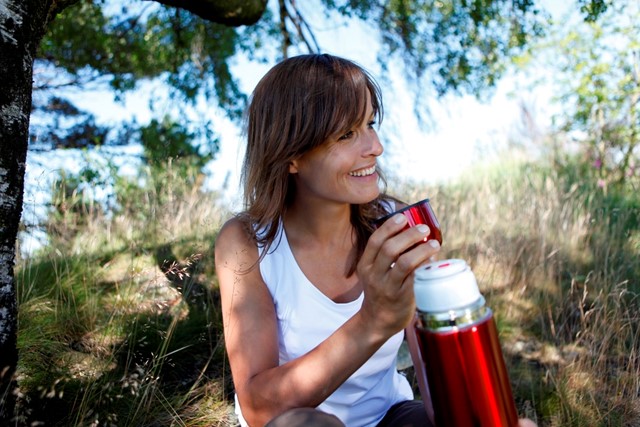 Vrouw met thermoskan 