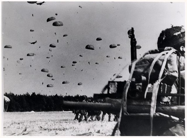 afbeelding van parachutisten die landen tijdens de oorlog.