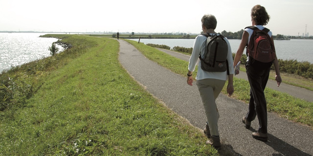 Duo wandelend over een dijk