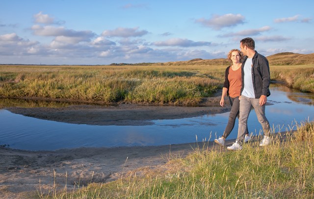 Duo wandelend met water op de achtergrond