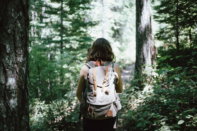 Vrouw in het bos met een rugzak