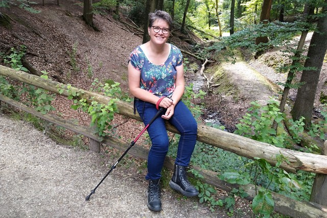 Mirjam Klever wandelt met een wandelstok in de natuur.