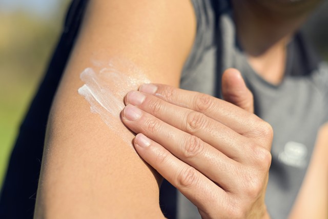 afbeelding van iemand die zich insmeert met zonnebrandcrème.