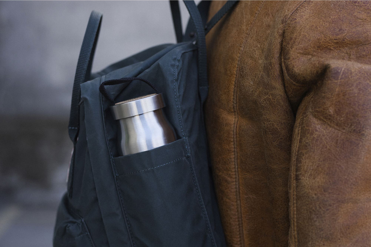 afbeelding van een thermosfles in het zijvak van een rugzak.